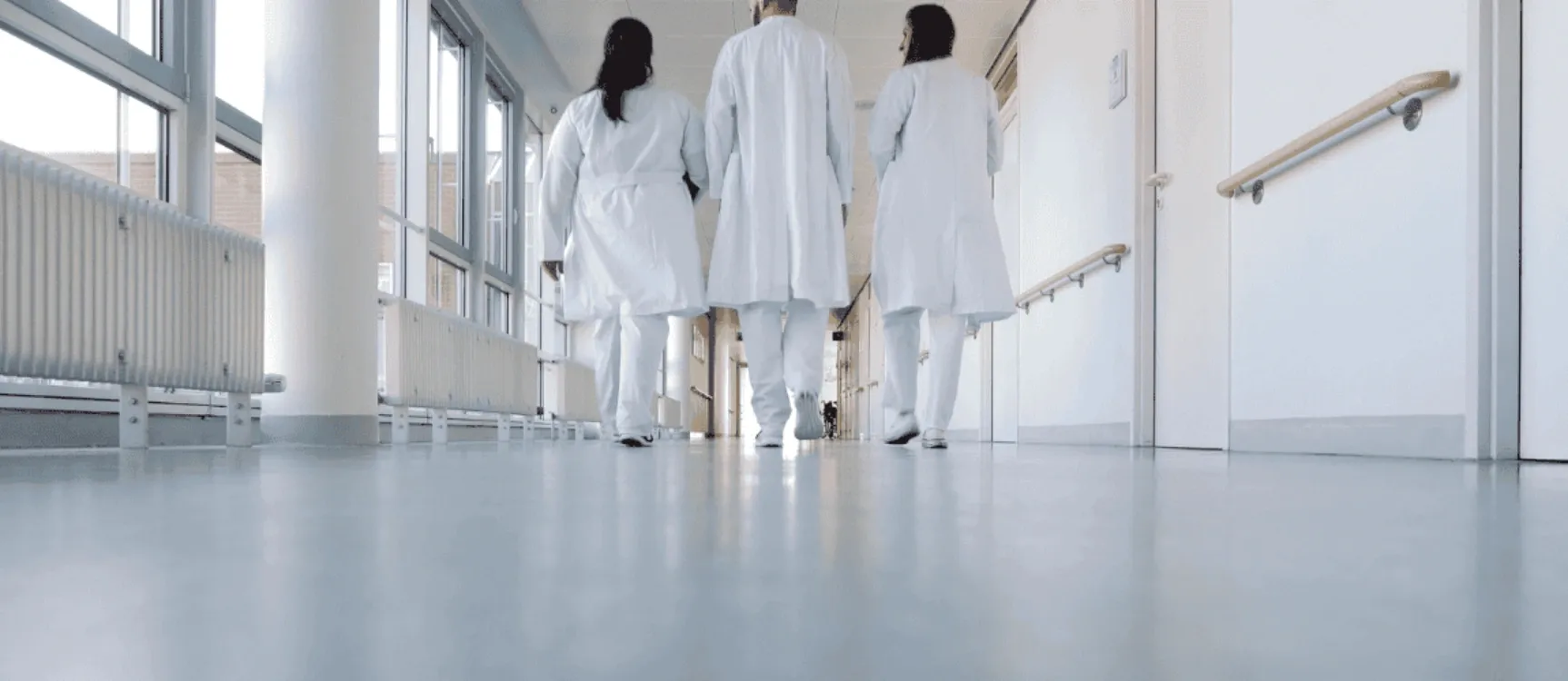 Pfleger laufen Krankenhausgang entlang