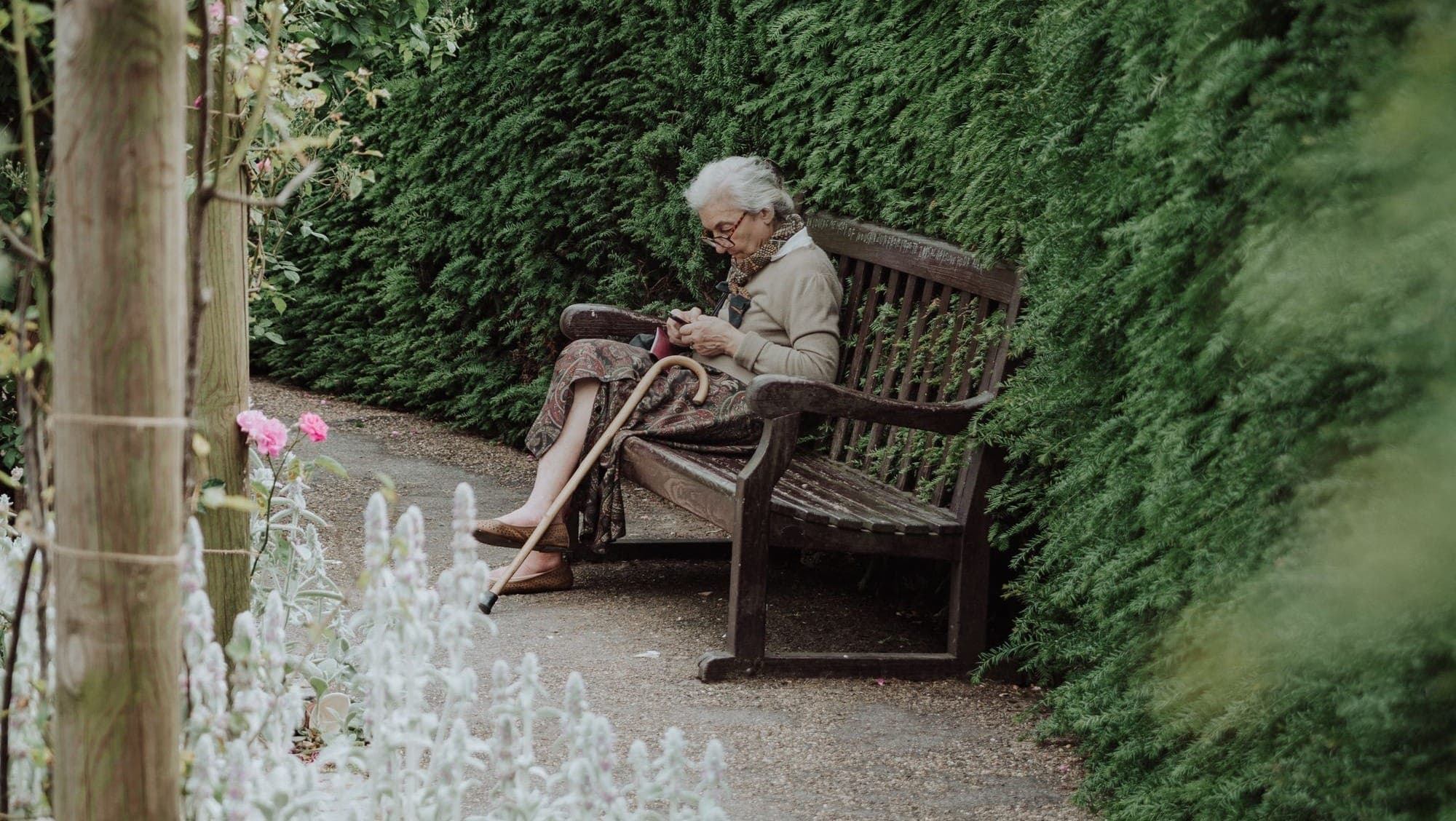 Alte Frau sitzt auf der Bank