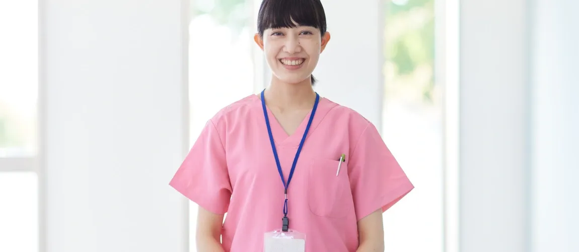 Eine Pflegefachkraft lächelt in die Kamera.