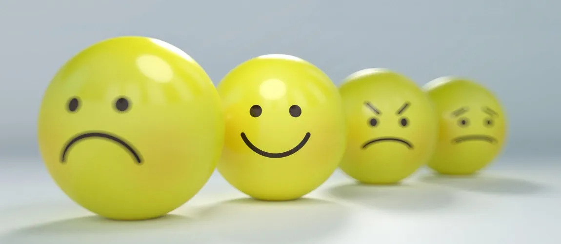 Abbildung von vier gelben Gesichtern in Ballform mit unterschiedlichen Emotionen.