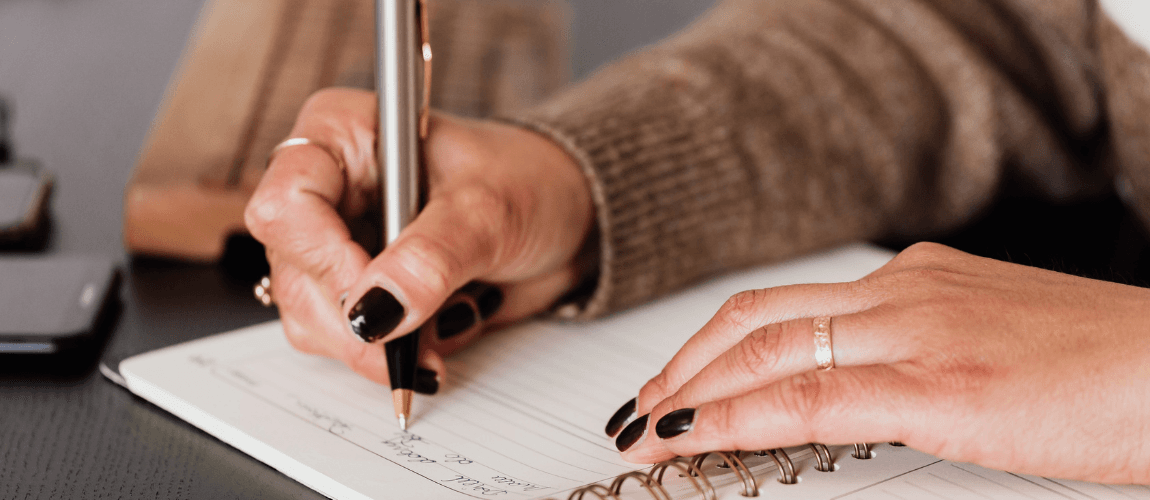 Eine Frau macht Notizen in einem Buch.