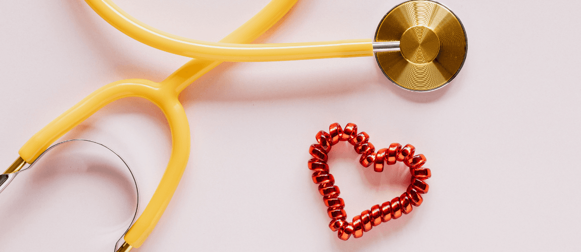 Ein Stethoskop liegt neben einem drapiertem Herz.